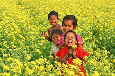 children laughing in field of flowers